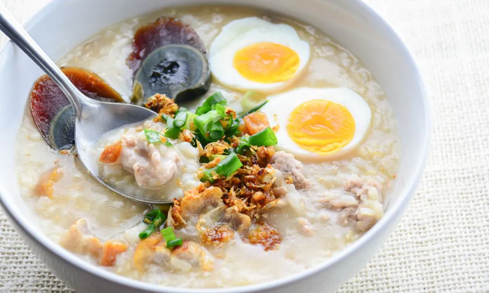 Congee with century egg, soft-boiled egg, pork, and crispy garnish at Canto House, a Chinese restaurant in Philadelphia